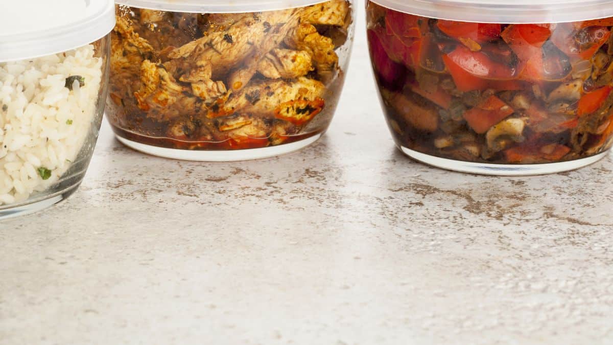 Three glass jars filled with rice and vegetables.