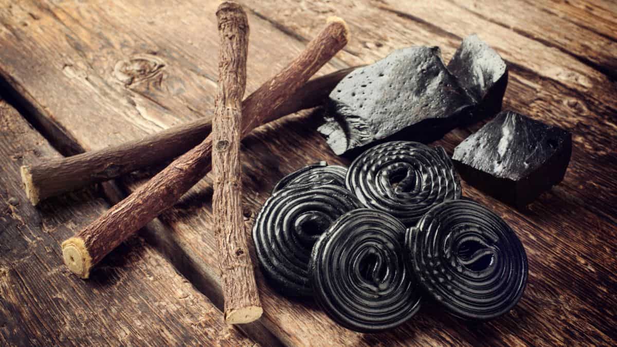 Black licorice sticks and sticks on a wooden table, often considered among the worst ice cream flavors.