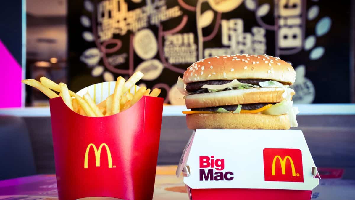 A mcdonald's big mac and fries on a table with branded packaging.