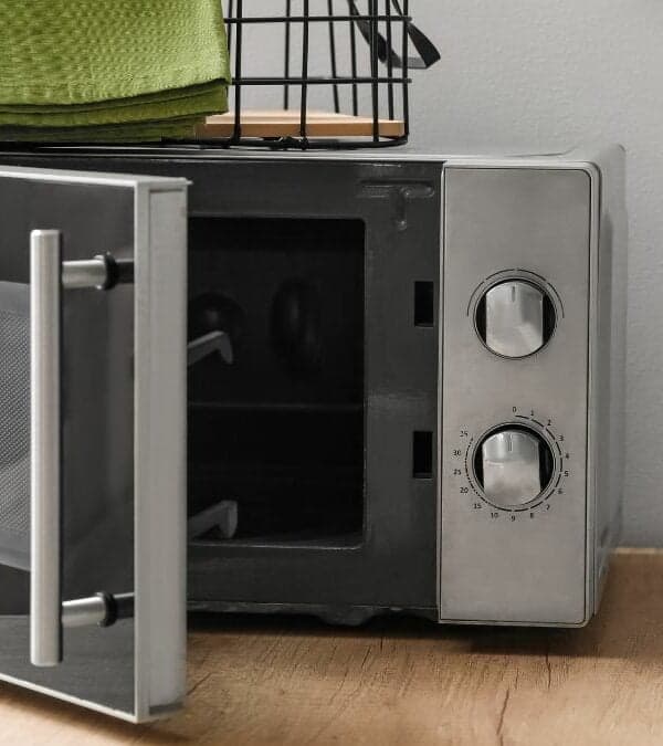 A modern microwave oven with its door open on a wooden countertop.
