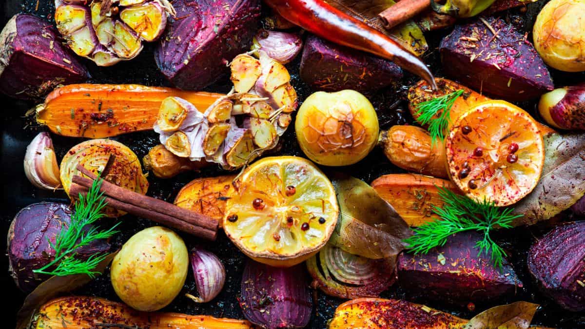 Roasted beets, carrots, onions and spices in a pan.