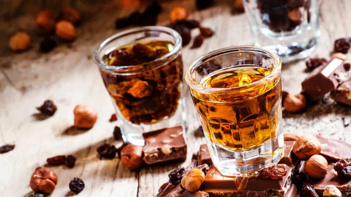 A shot of rum and chocolate on a wooden table.