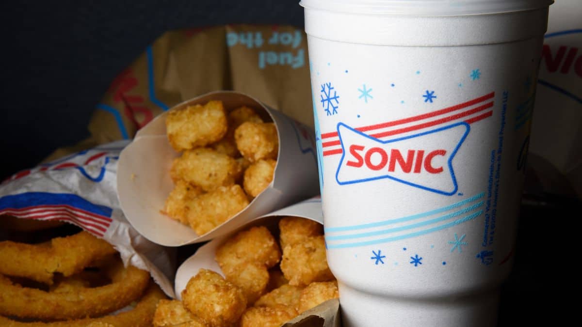 A sonic fast-food meal featuring tater tots and onion rings with a beverage cup.
