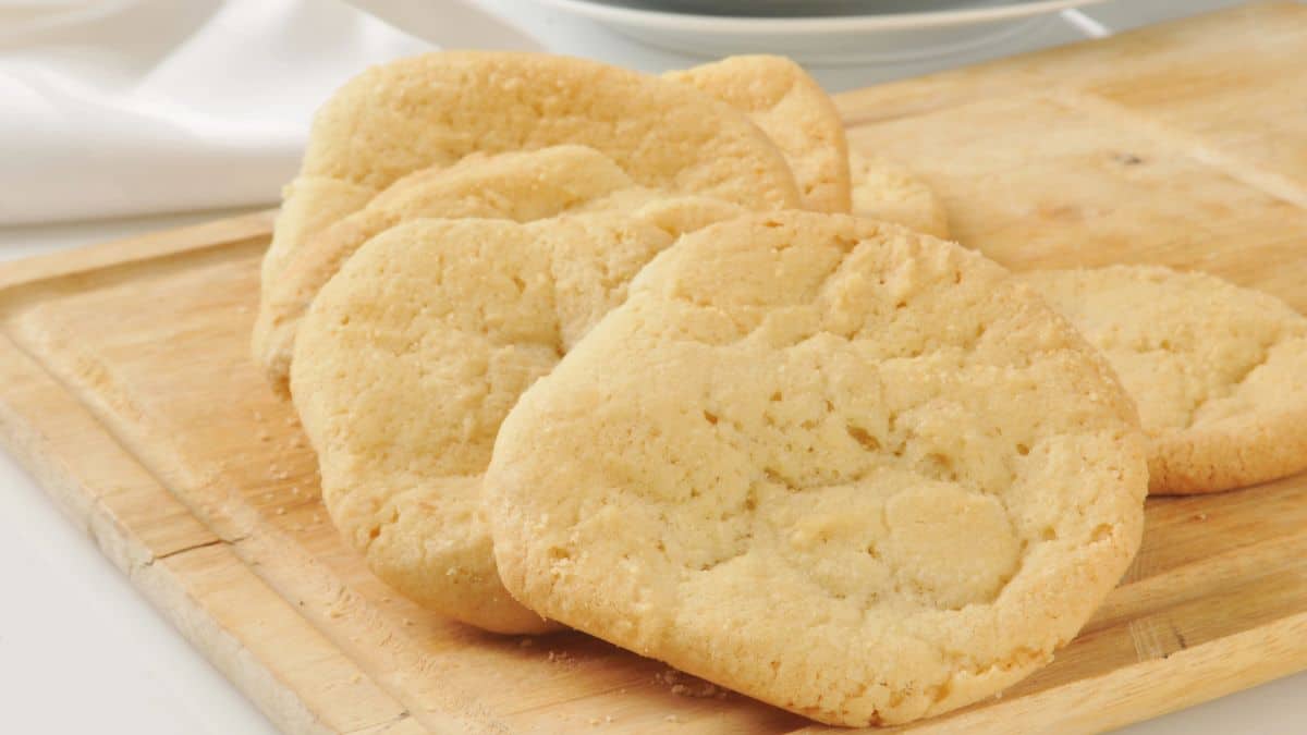 Sugar cookies on a wooden cutting board.