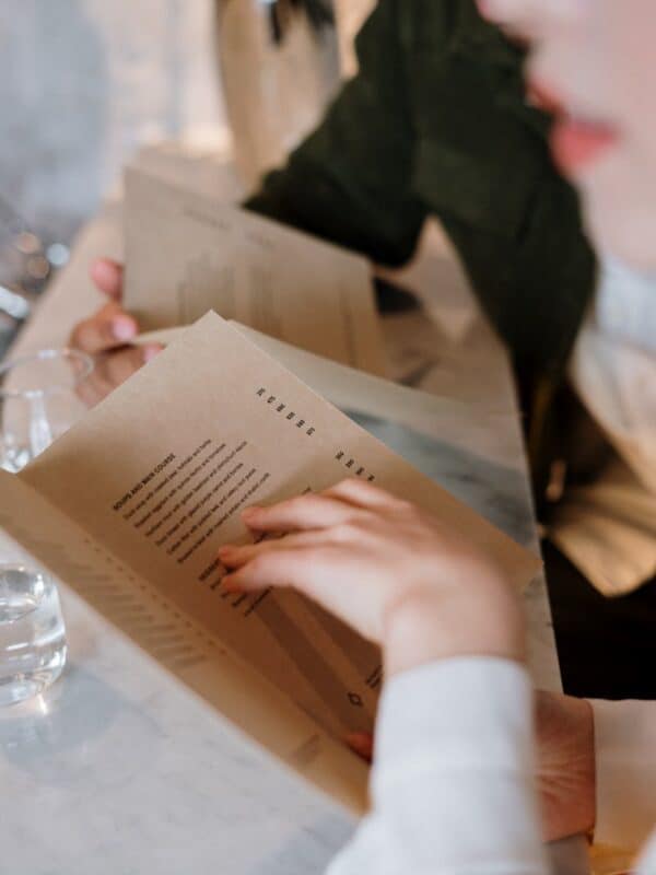 Two people reading a gluten-free menu at a restaurant.