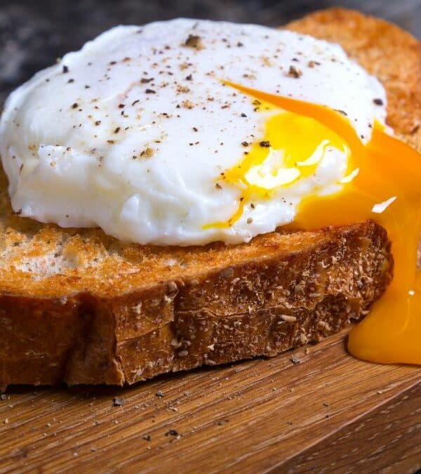 Poached egg with a runny yolk on toasted bread.