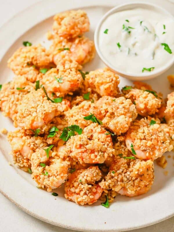 A plate of popcorn shrimp with a dipping sauce.