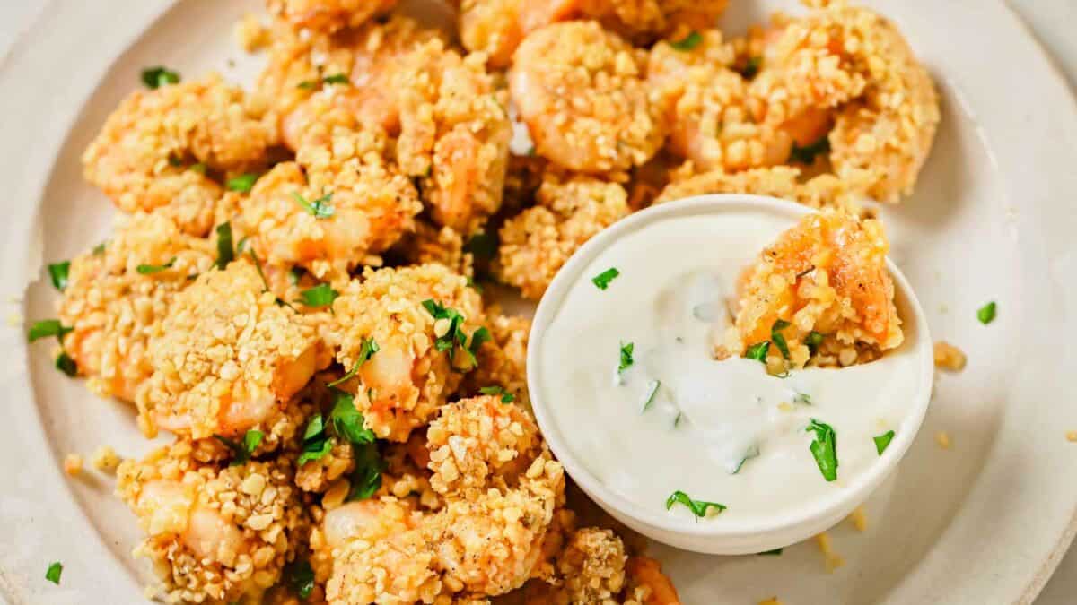 Popcorn shrimp with a dip on a plate.
