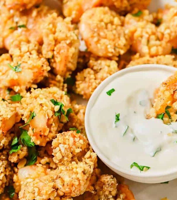 Popcorn shrimp with a dip on a plate.