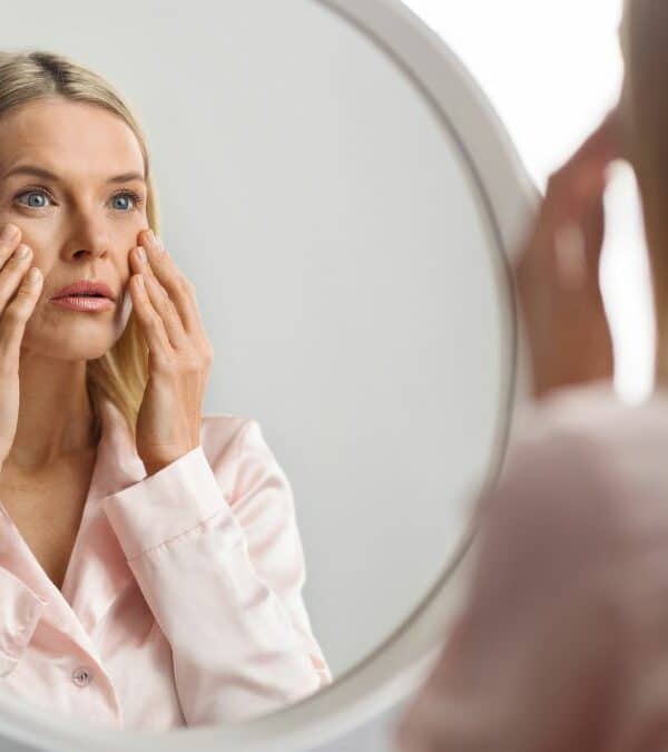Woman examining her face in the mirror.