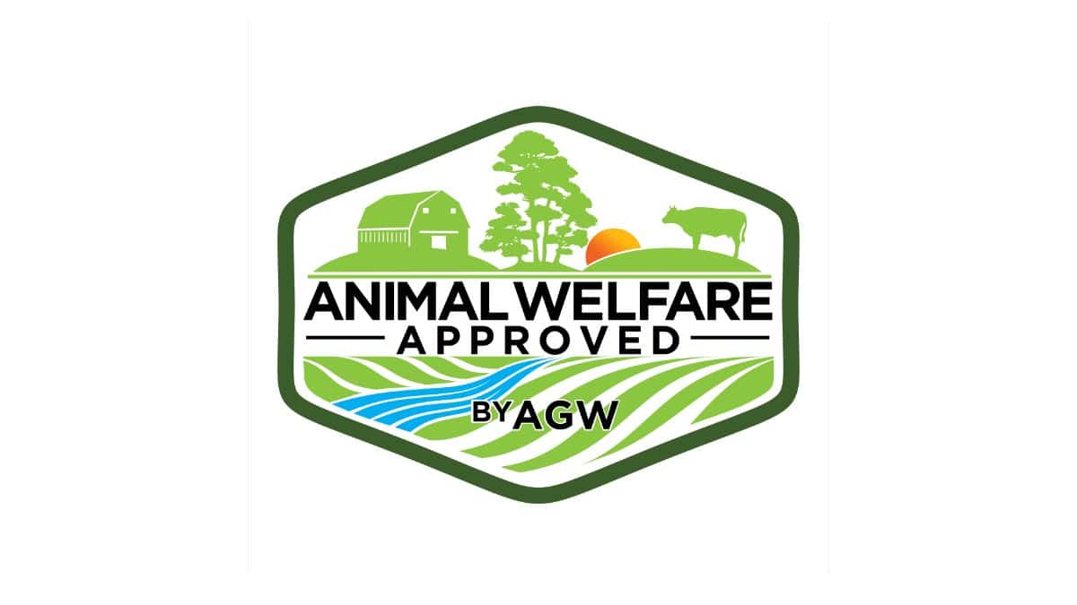Logo of "animal welfare approved by agw" featuring a farm scene with a barn, trees, a setting sun, a cow, and stylized water waves.