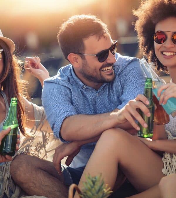 Group of friends enjoying drinks and laughter outdoors.