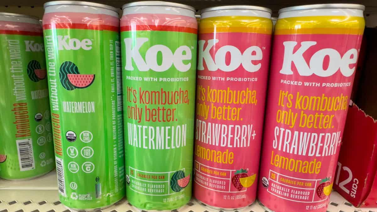 Cans of koe kombucha in watermelon and strawberry lemonade flavors on a shelf.
