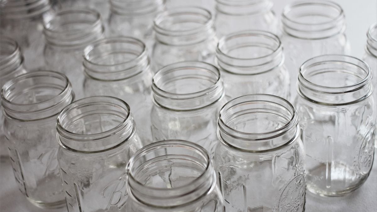 Empty glass jars arranged on a white surface.