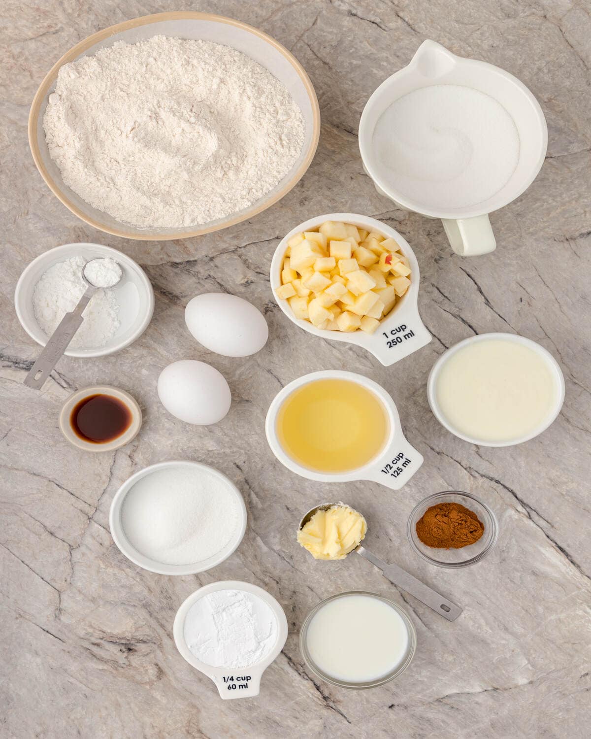 Ingredients for baking arranged on a marble surface.