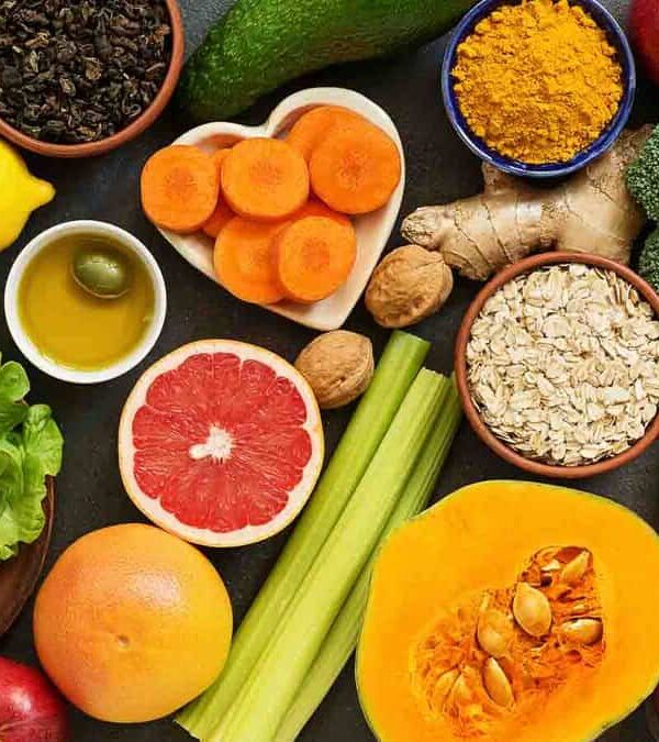 Assorted fresh fruits and vegetables on a gray surface.