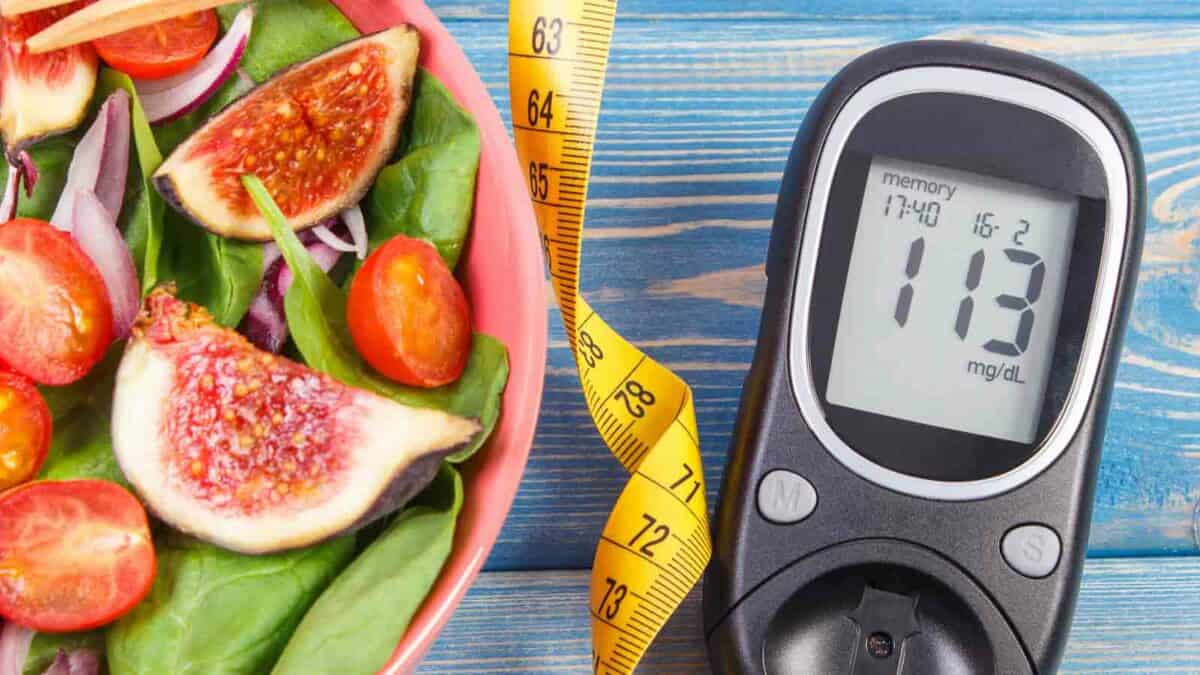 Healthy salad with glucose meter and measuring tape indicating a focus on diet for diabetes management.