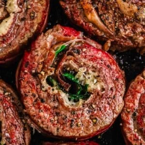 Close-up of seasoned rolled flank steak pinwheel cooked to a golden brown.