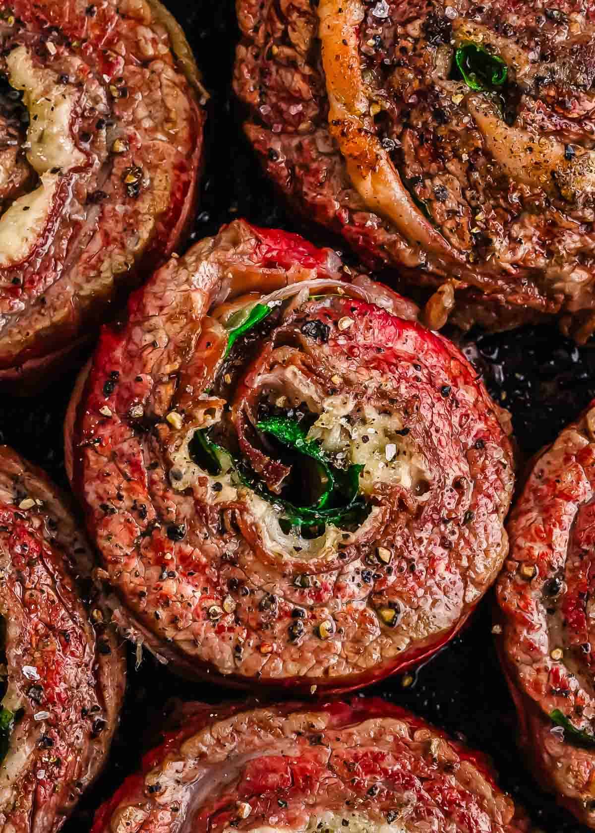 Close-up of seasoned rolled flank steak pinwheel cooked to a golden brown.