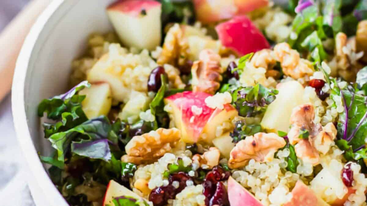 Quinoa salad with apples, walnuts, kale, and cranberries in a bowl.