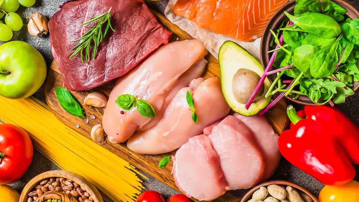 Raw meat, seafood, vegetables and grains spread out.