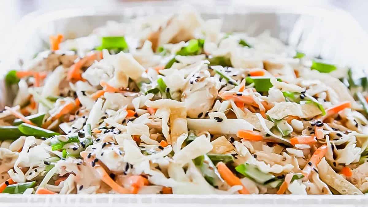 A close-up image of a mixed vegetable stir-fry garnished with sesame seeds.