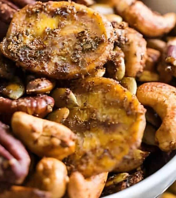 A close-up view of a bowl filled with assorted nuts and banana chips.