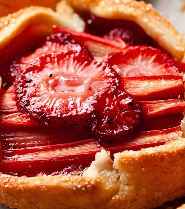 Close-up of a freshly baked strawberry tart with golden crust and glazed strawberry slices arranged in a circular pattern.