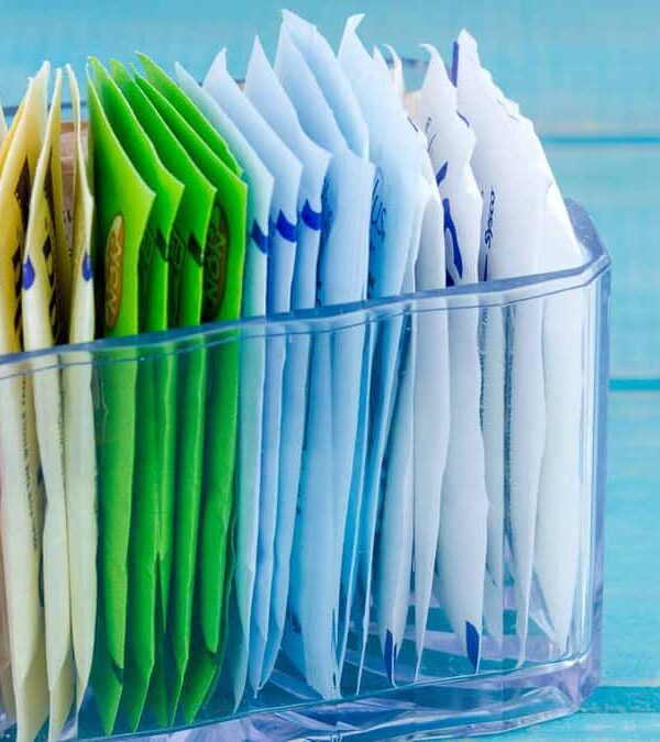 A clear plastic organizer containing multiple colored and white file folders on a blue wooden surface.