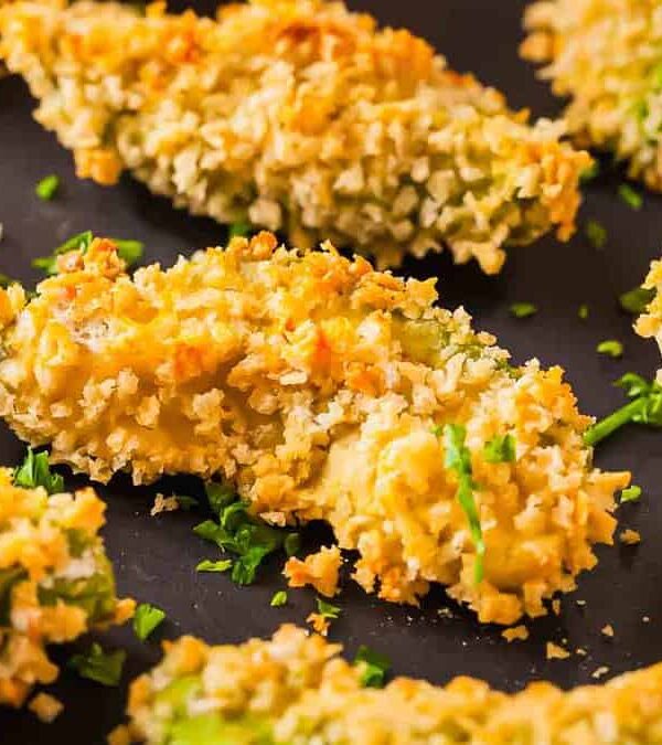 Avocado fries on dark surface.