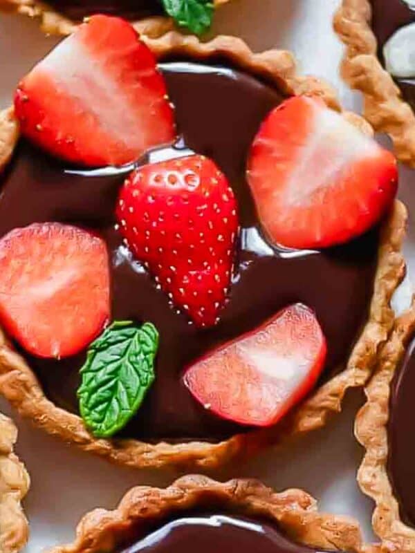 Chocolate strawberry tartlets with mint leaves.