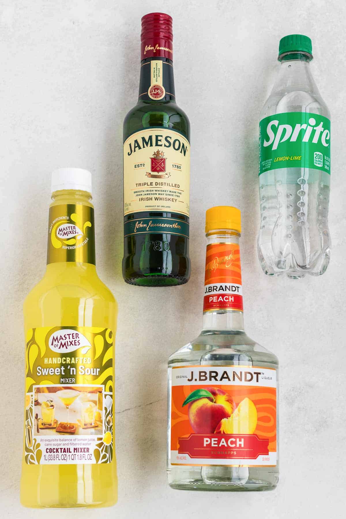 Bottles of Jameson, Sprite, Peach Schnapps and Sweet and Sour mix to make a green tea shot.