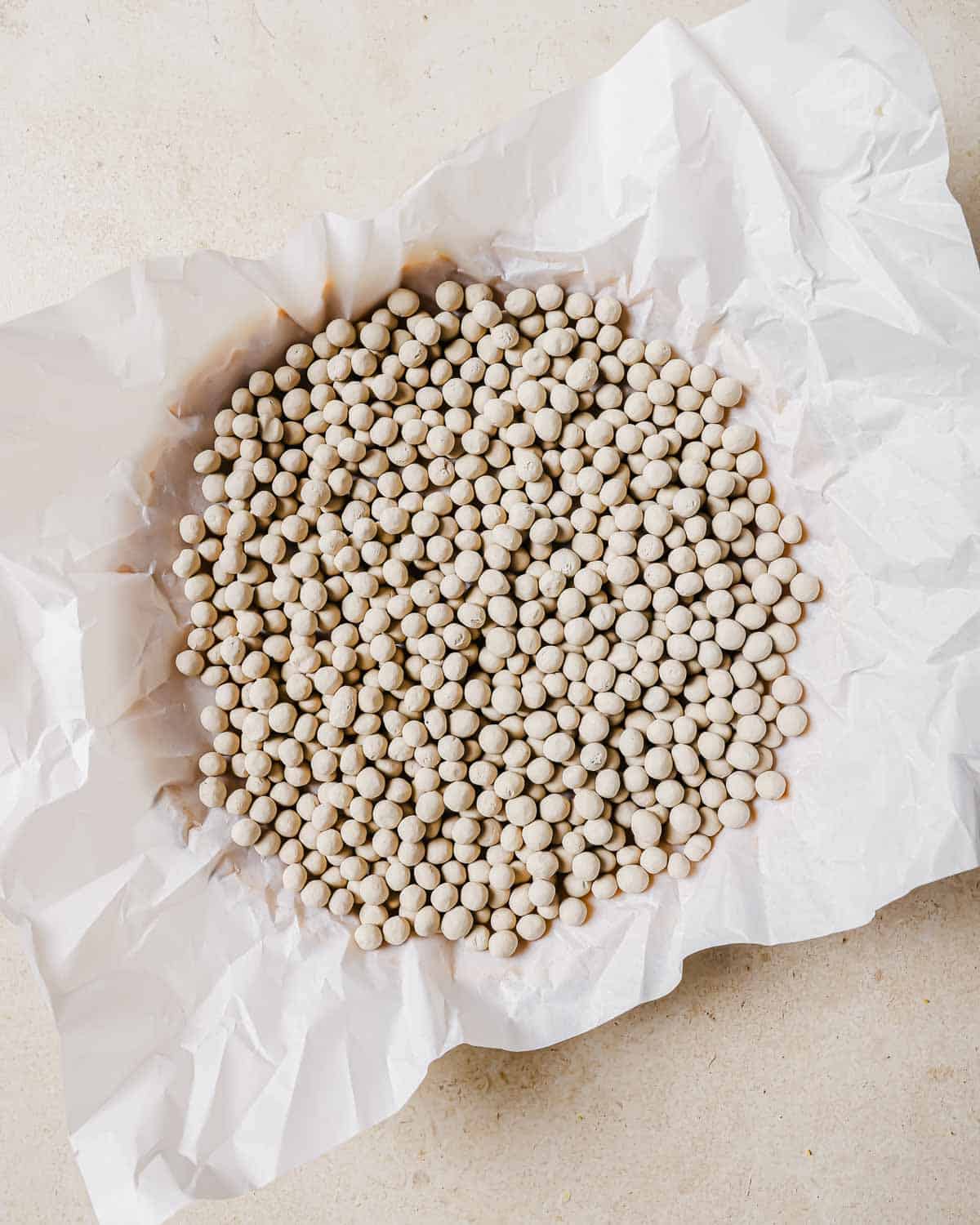 Dry baking beans on parchment paper, spread out evenly on a light surface.