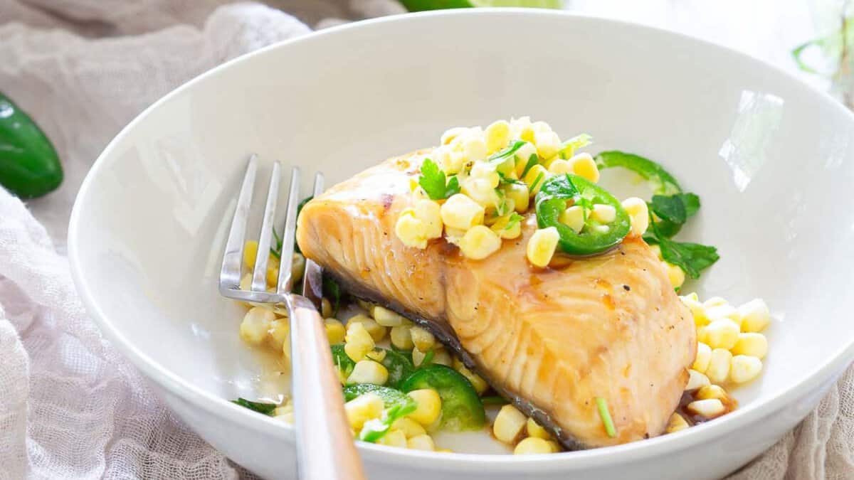 Honey lime sablefish with jalapeño corn salsa in a bowl with a fork.