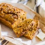 Two slices of carrot bread cut off a loaf with a butter spreader on the side.