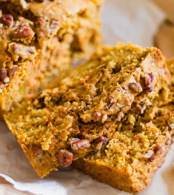 Pecan topped carrot bread slices on parchment paper.