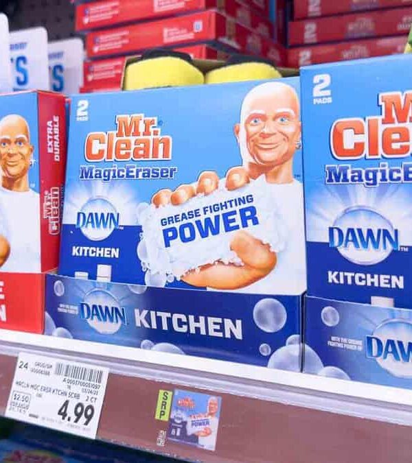 Boxes of Mr. Clean MagicEraser sponges are displayed on a store shelf. The labels show different types: "Whole Home Power Clean" and "Kitchen Grease Fighting Power." Prices and product details are visible.