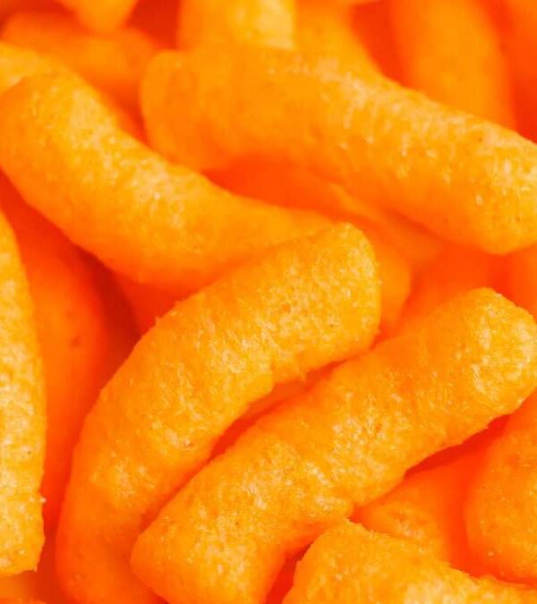 Close-up of bright orange cheese puffs clustered together.