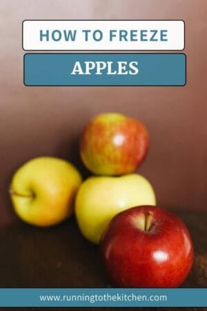 Four apples in various colors are stacked against a brown backdrop, with the text "Learn How to Freeze Apples" overlaying the image. At the bottom, you'll find the website link: www.runningtothekitchen.com.