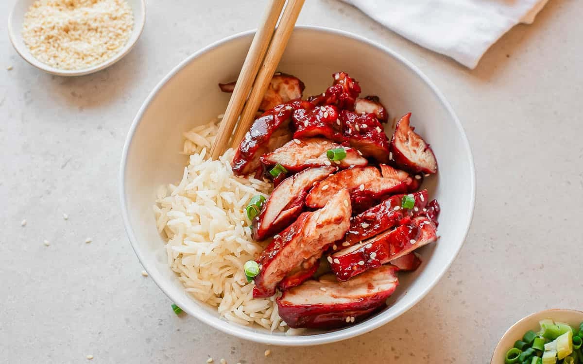 Glazed char siu chicken pieces with a rich, glossy red sauce served over rice.