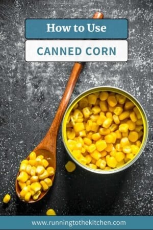 An open can of corn with a wooden spoon beside it, both filled with yellow corn kernels, on a dark textured surface. Text above reads “How to Use Canned Corn.” Website link at the bottom.
