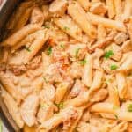 A cooking pan of marry me chicken pasta with creamy sauce and parsley.