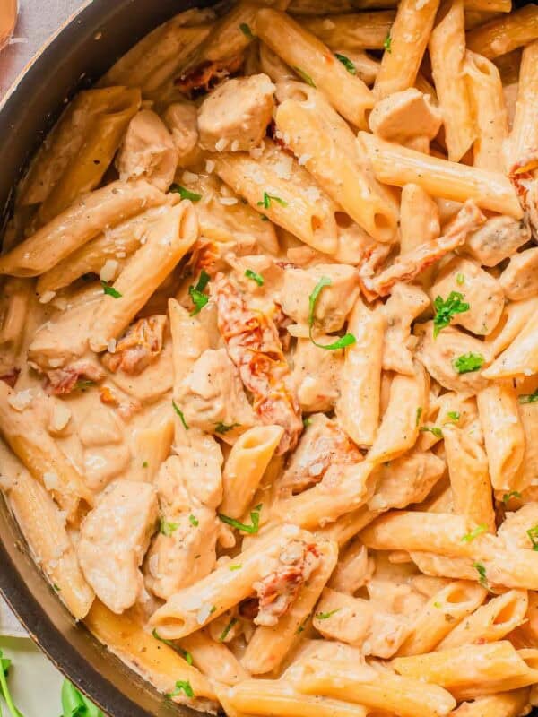 A cooking pan of marry me chicken pasta with creamy sauce and parsley.