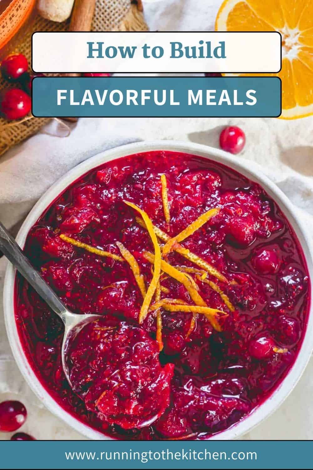 A bowl of chunky cranberry sauce garnished with orange zest, with a spoon inside, sits on a white cloth next to an orange slice. Text above reads, "Building Flavorful Meals." Website URL at the bottom.