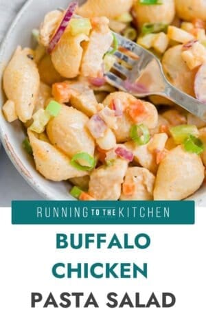 A bowl of pasta salad with shell pasta, chicken, diced vegetables, and green onions, tossed in a creamy buffalo sauce, with a fork in the bowl. Text overlay reads: "Buffalo Chicken Pasta Salad.