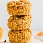 A vertical stack of three baked banana carrot muffins.