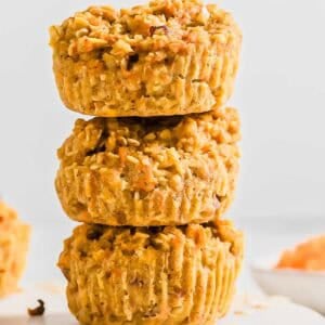 A vertical stack of three baked banana carrot muffins.