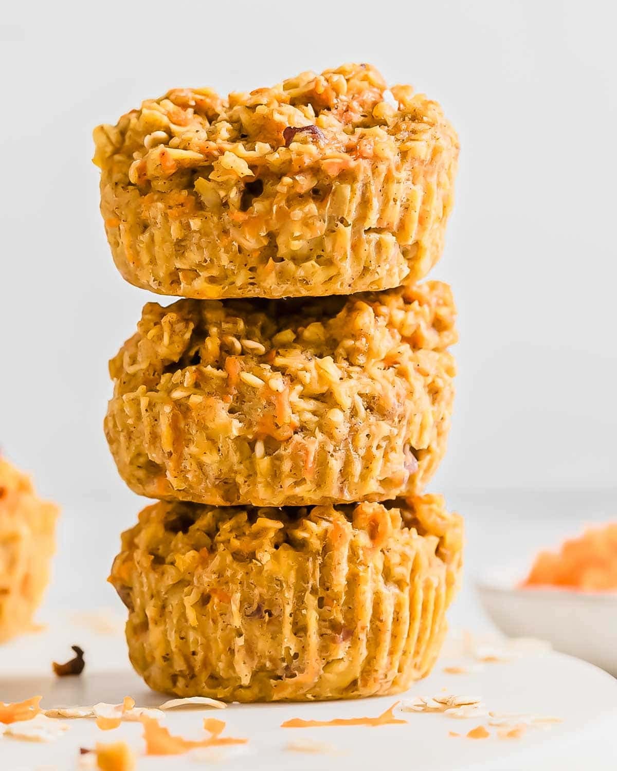 A vertical stack of three baked banana carrot muffins.